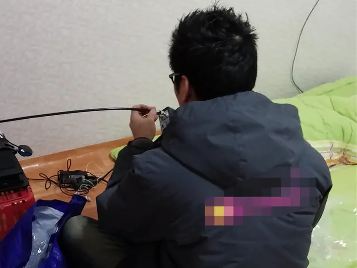 실내 케이블 연결부를 점검하는 설치 작업자의 뒷모습